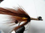 Prepare another brown schlappen feather by removing the webby base AND stripping one side of the feather. Create a dubbing loop about 4" long for later in the process. Work the thread forward and tie a set of eyes (beadchain, lead, or omit) on top of the shank. Secure with superglue.